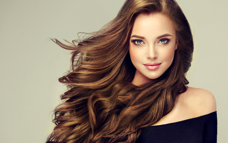 105387627-young-brown-haired-woman-with-voluminous-hair-beautiful-model-with-long-dense-curly-hairstyle-and-vi  - Aqua Salon & Spa